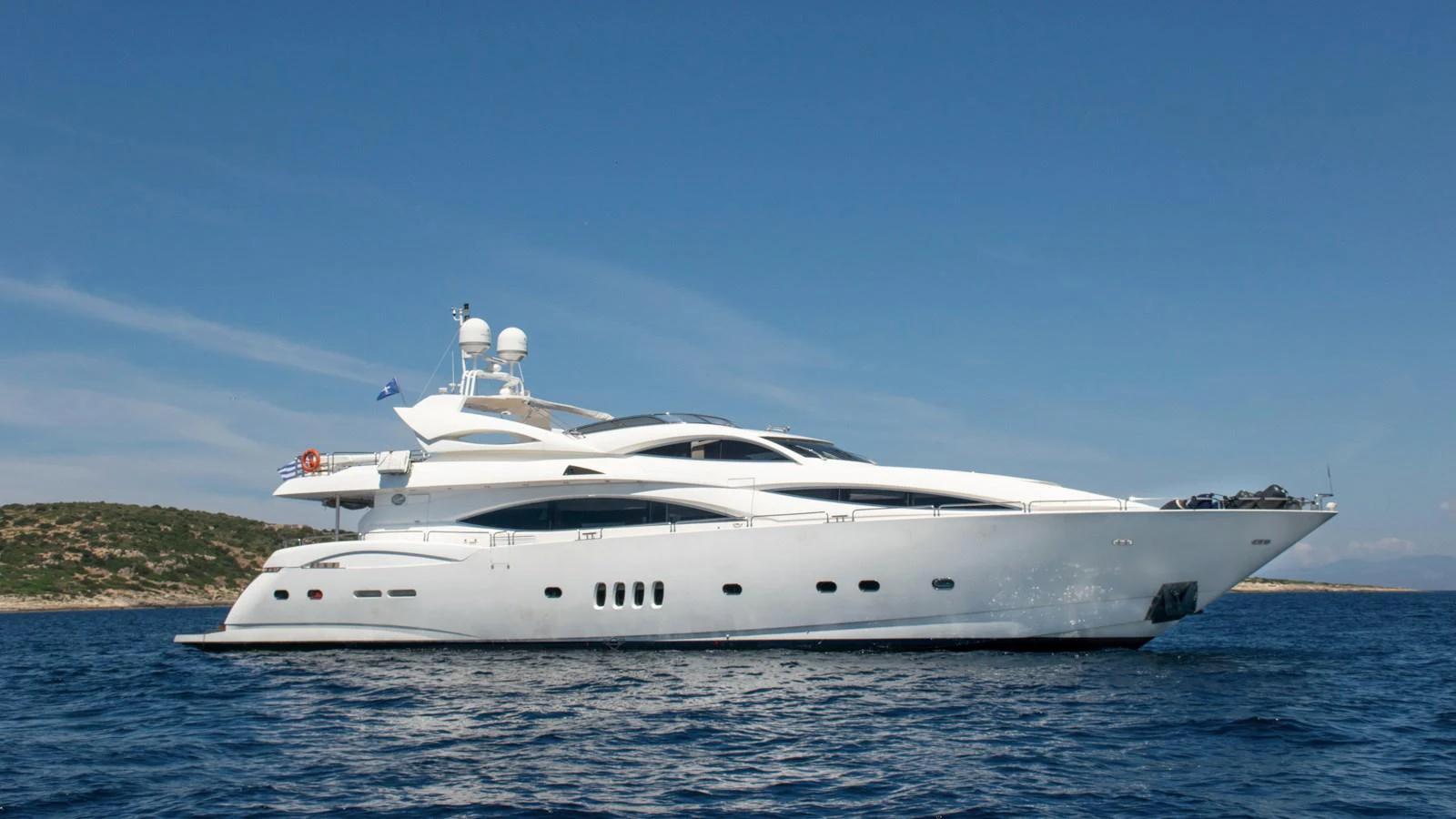 A sleek and modern yacht glides gracefully on calm blue waters under a clear sky. aboard MI ALMA Yacht for Sale