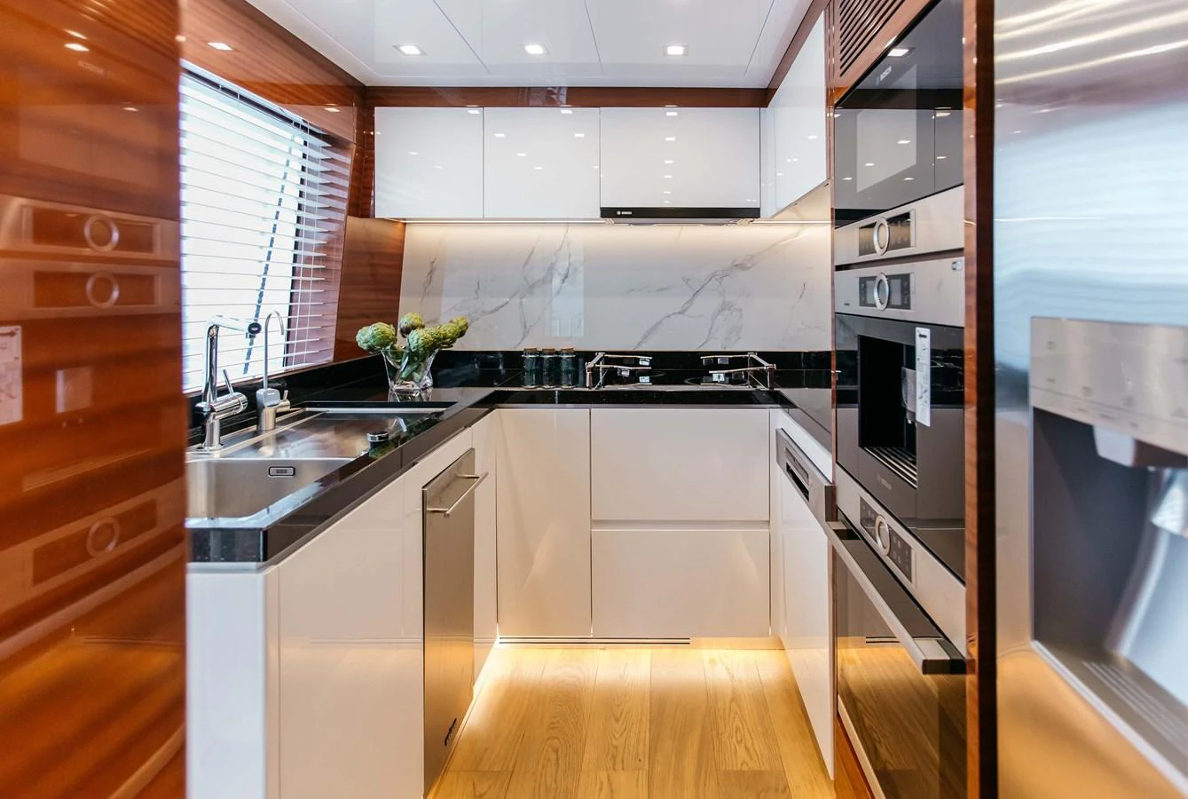 a kitchen with white cabinets aboard PAPILLON Yacht for Sale