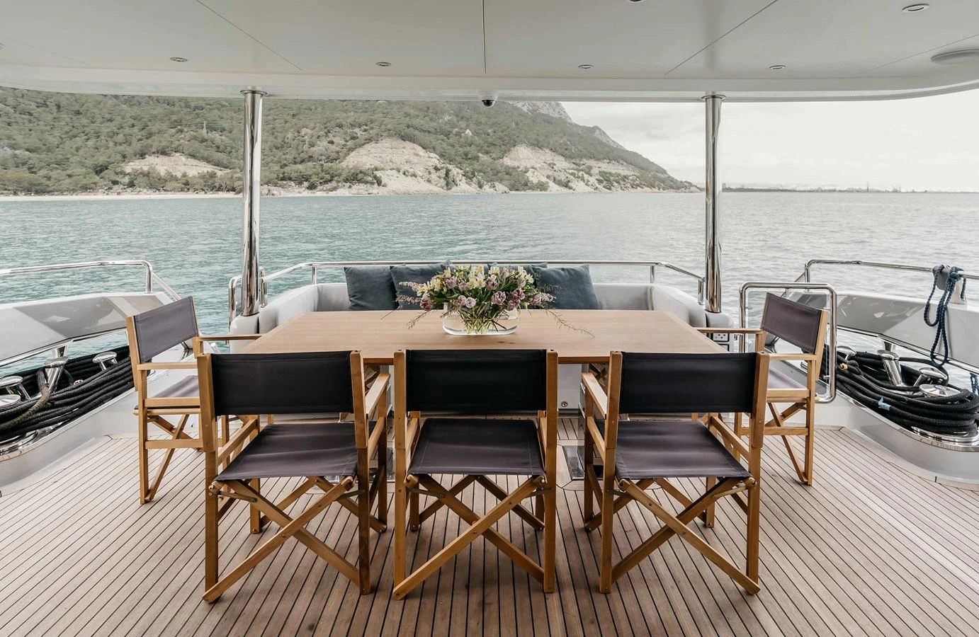 a table and chairs on a deck overlooking a body of water aboard PAPILLON Yacht for Sale