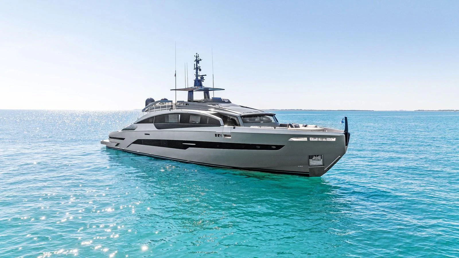 A sleek, modern yacht glides gracefully on calm, turquoise waters under a clear blue sky. aboard CAFFEINE Yacht for Sale
