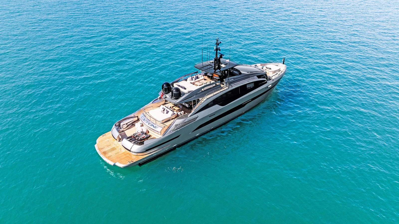 A sleek and modern yacht glides effortlessly on the clear blue waters. aboard CAFFEINE Yacht for Sale