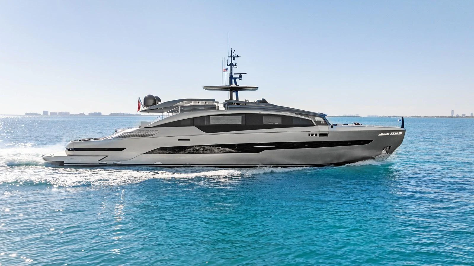 A sleek and modern yacht cruising on calm blue waters under a clear sky. aboard CAFFEINE Yacht for Sale