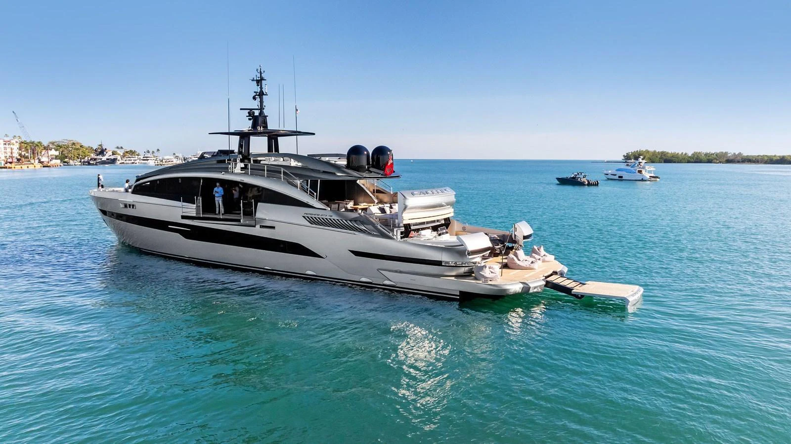 A sleek and modern yacht cruising on tranquil blue waters with a clear sky backdrop. aboard CAFFEINE Yacht for Sale