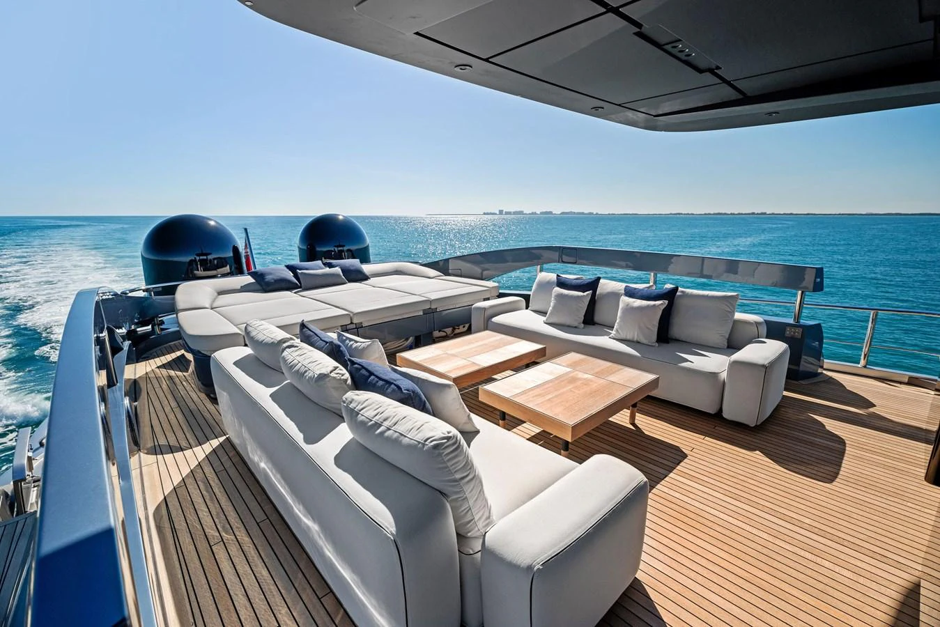 The aft deck offers a luxurious outdoor lounging area with plush seating and stunning ocean views. aboard CAFFEINE Yacht for Sale