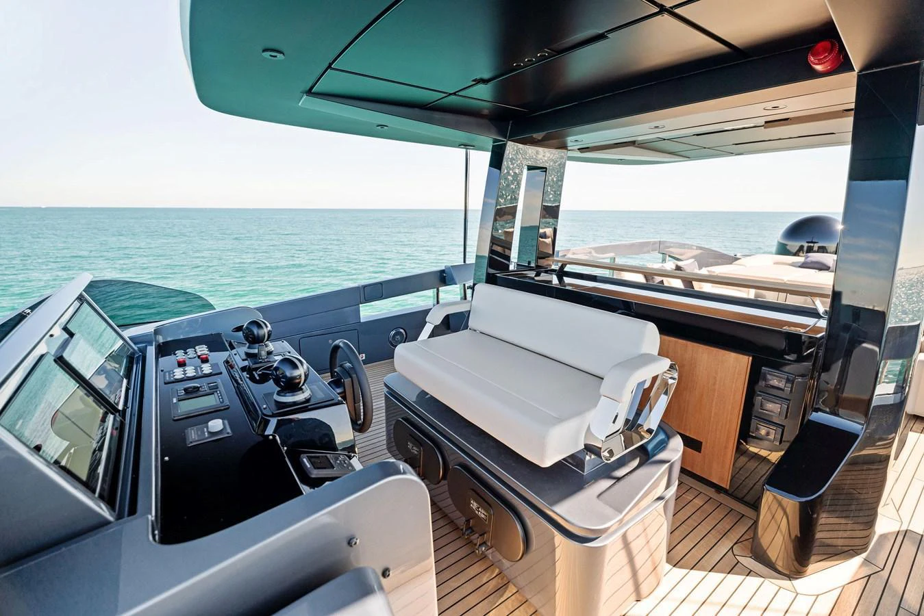 The yacht's helm station features modern controls and a comfortable seating area with a stunning view of the open sea. aboard CAFFEINE Yacht for Sale