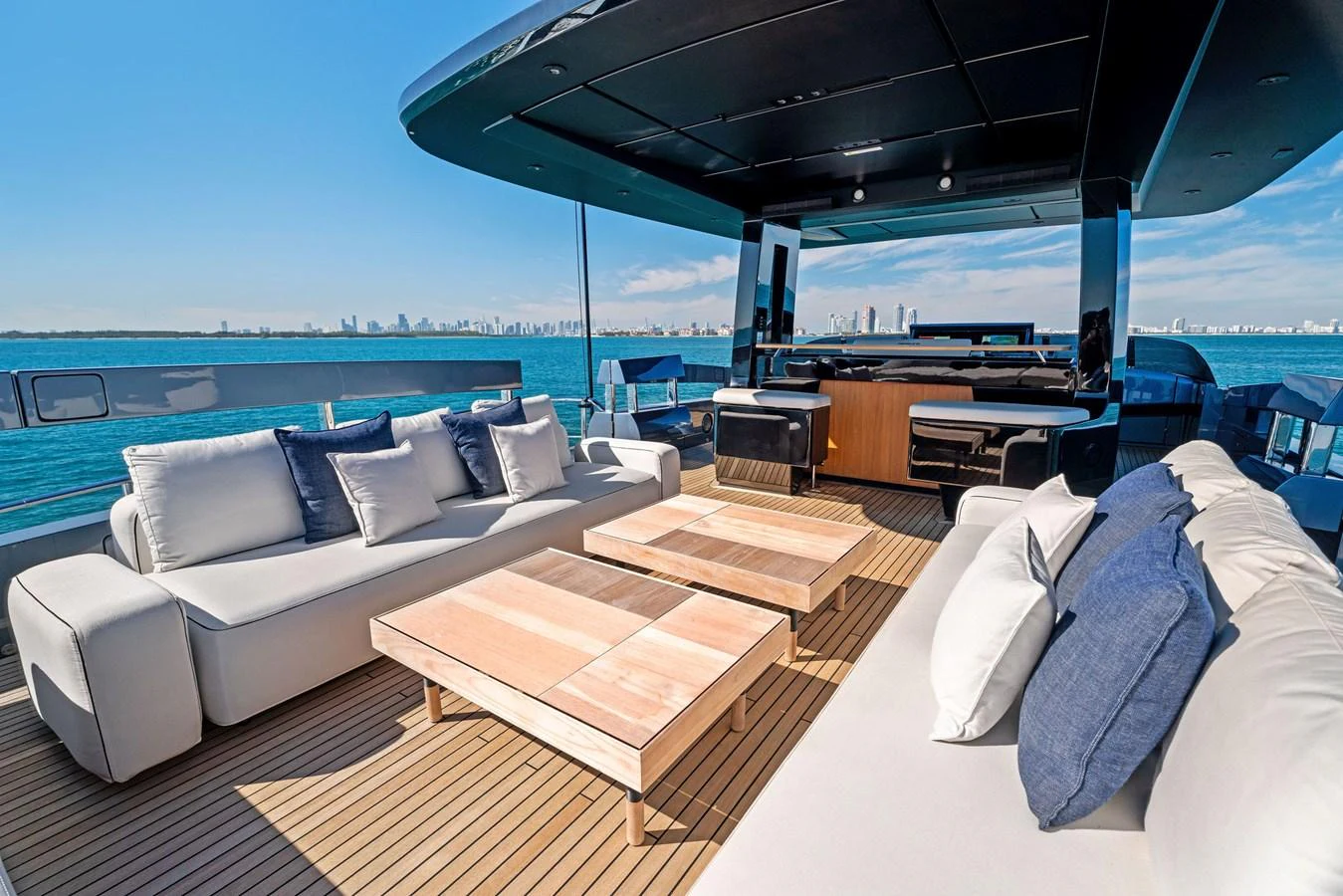 The aft deck offers a luxurious outdoor seating area with plush sofas and wooden tables, perfect for relaxation and entertainment. aboard CAFFEINE Yacht for Sale