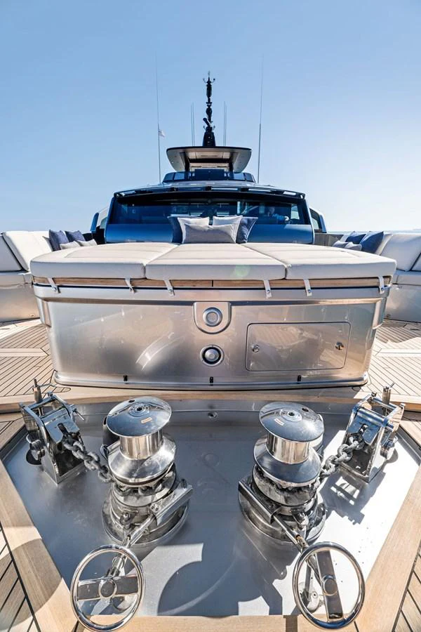 The foredeck of the yacht showcases polished anchor winches and a sleek design under clear skies. aboard CAFFEINE Yacht for Sale