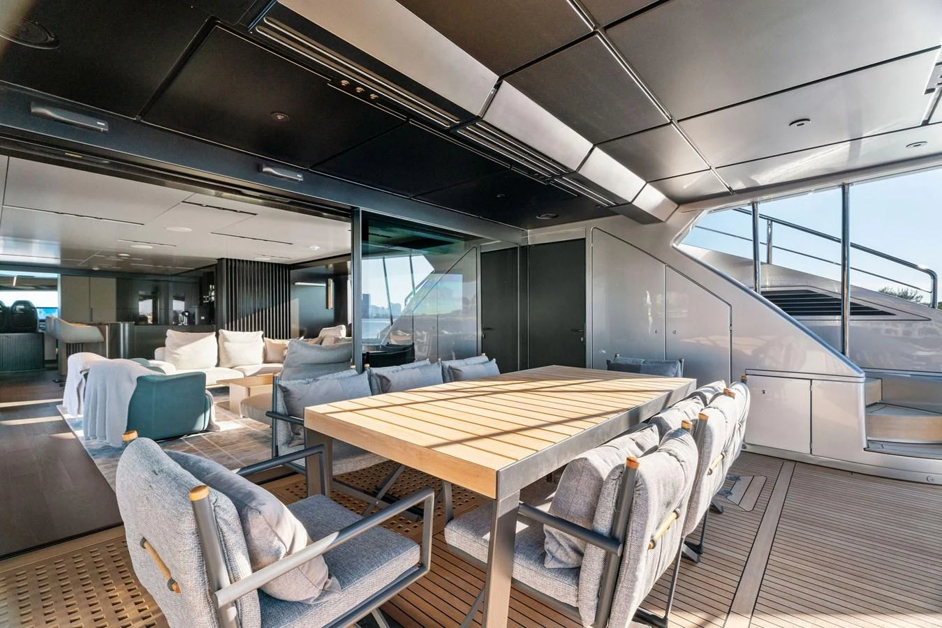 The aft deck features a spacious dining area with comfortable seating and a seamless transition to the interior lounge. aboard CAFFEINE Yacht for Sale
