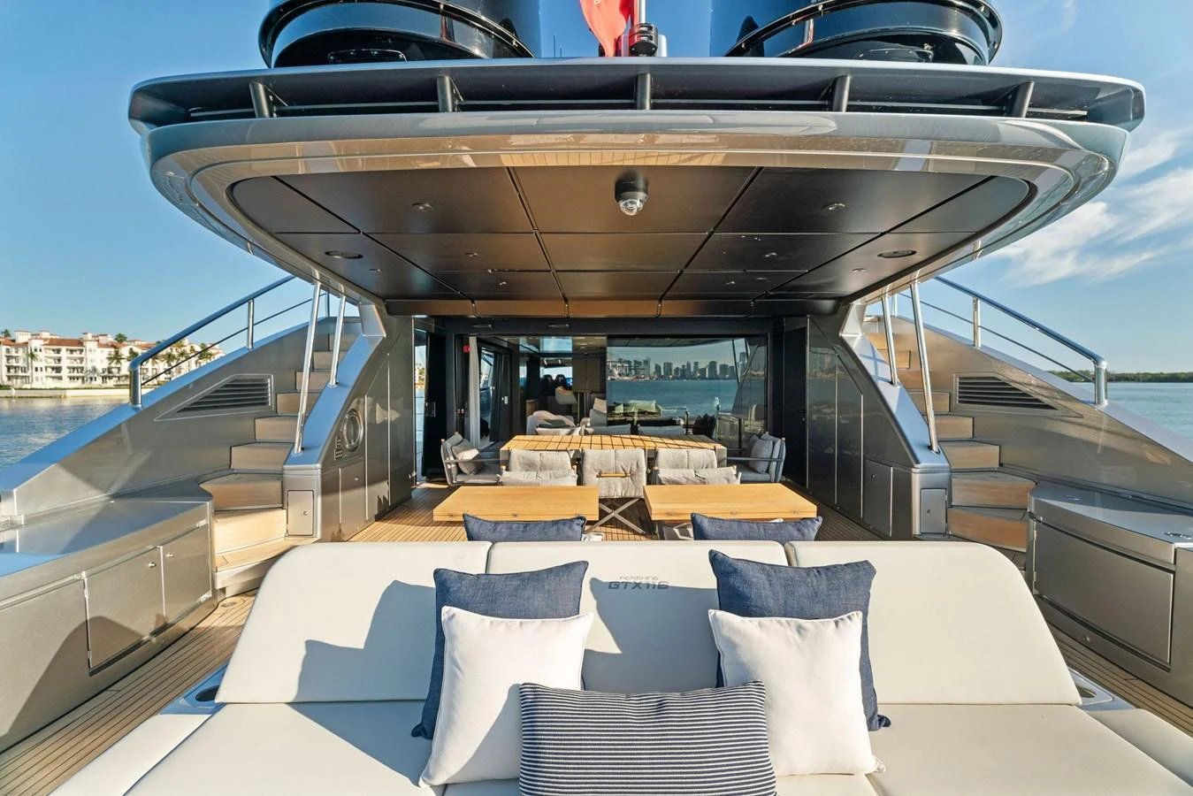 The aft deck features a luxurious seating area with plush cushions and a spacious dining setup, perfect for alfresco dining and relaxation. aboard CAFFEINE Yacht for Sale