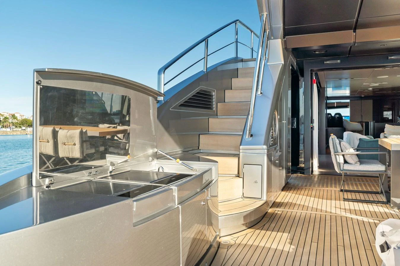 The aft deck features a sleek staircase and a modern outdoor kitchen area, perfect for entertaining. aboard CAFFEINE Yacht for Sale