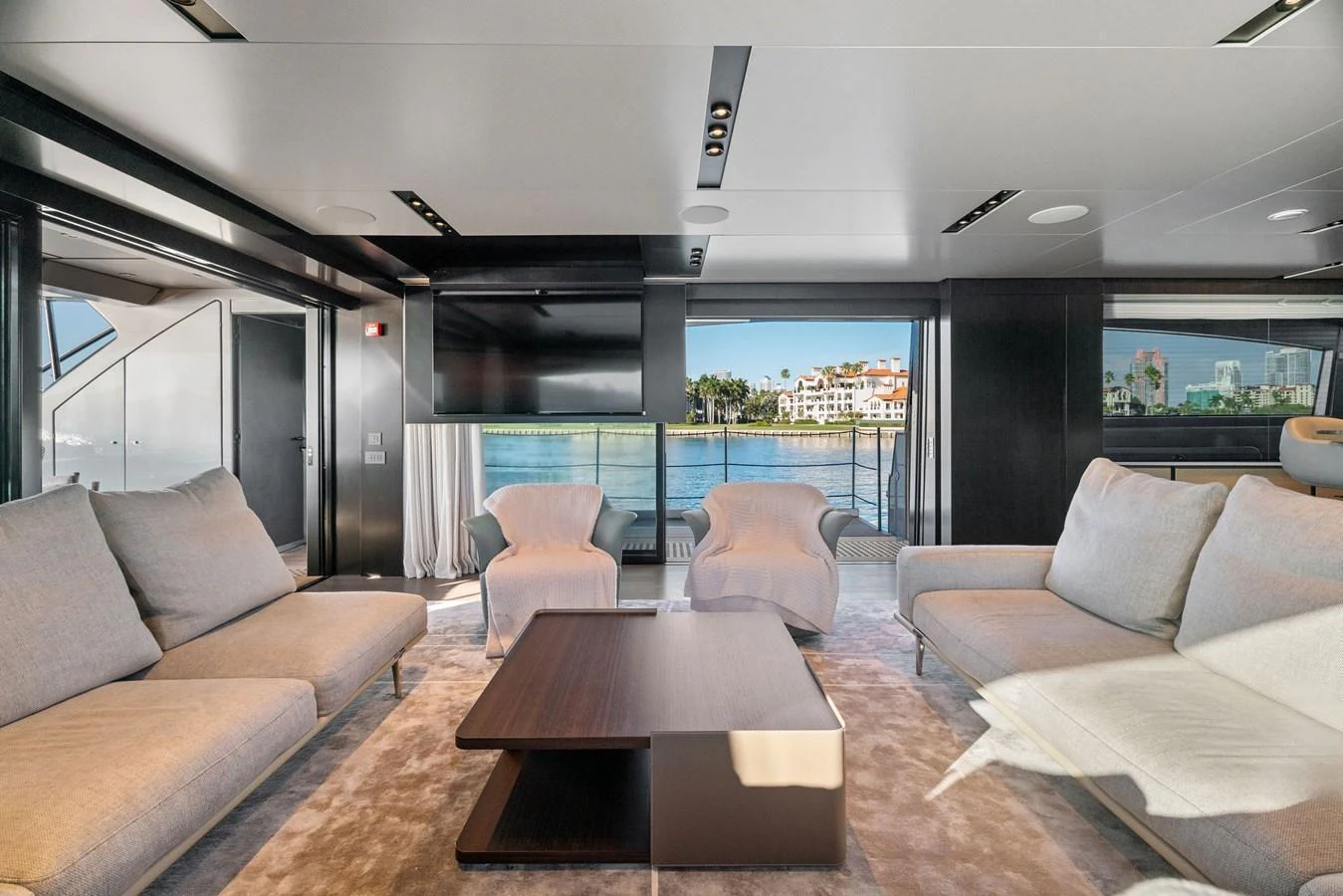 The salon features luxurious seating with a modern design and large windows offering stunning views. aboard CAFFEINE Yacht for Sale