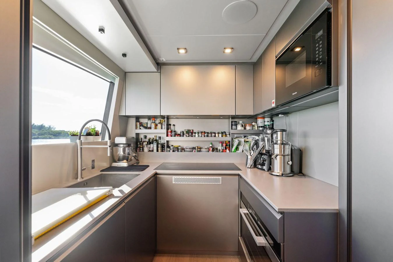 The galley is modern and well-equipped, featuring sleek cabinetry and ample counter space. aboard CAFFEINE Yacht for Sale
