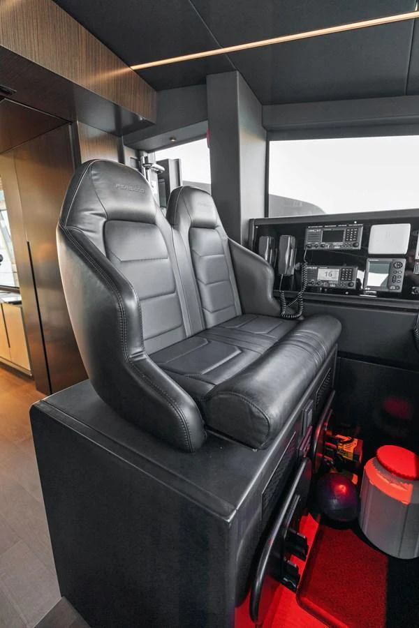 The helm features sleek black leather seating and advanced navigation equipment. aboard CAFFEINE Yacht for Sale