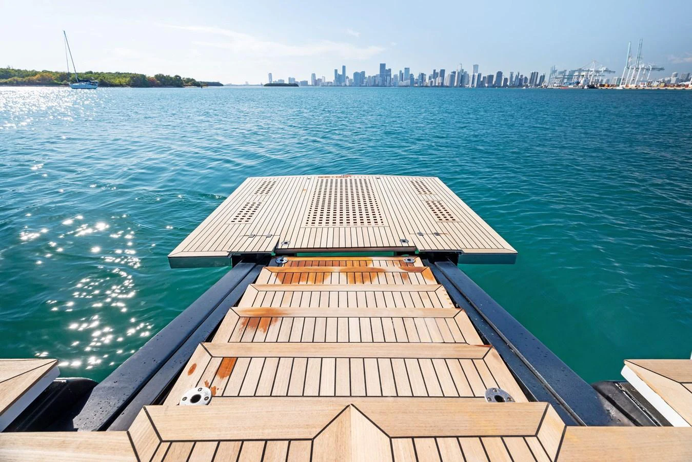 The yacht features a spacious swim platform with a stunning view of the city skyline. aboard CAFFEINE Yacht for Sale