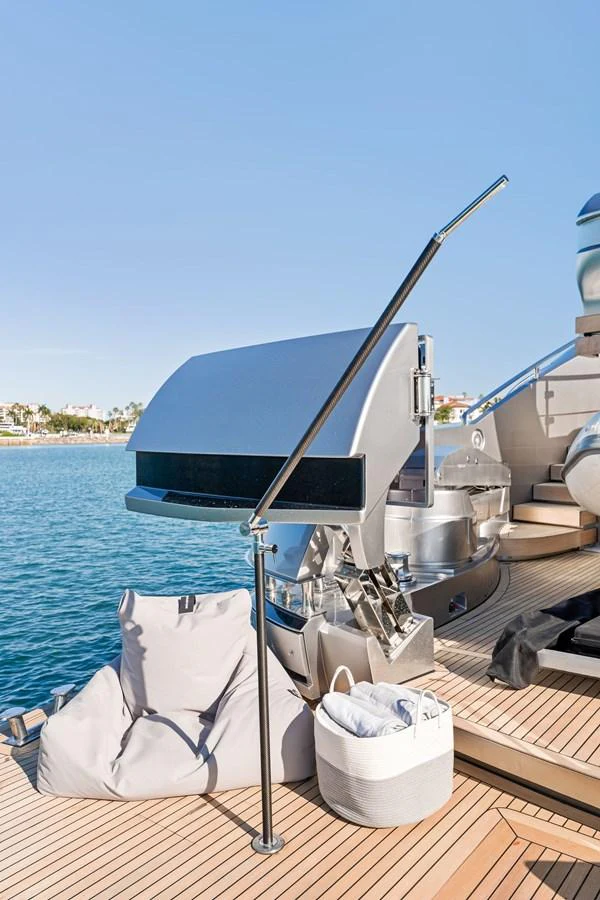 A close-up view of a yacht's deck featuring a modern grill and seating area. aboard CAFFEINE Yacht for Sale