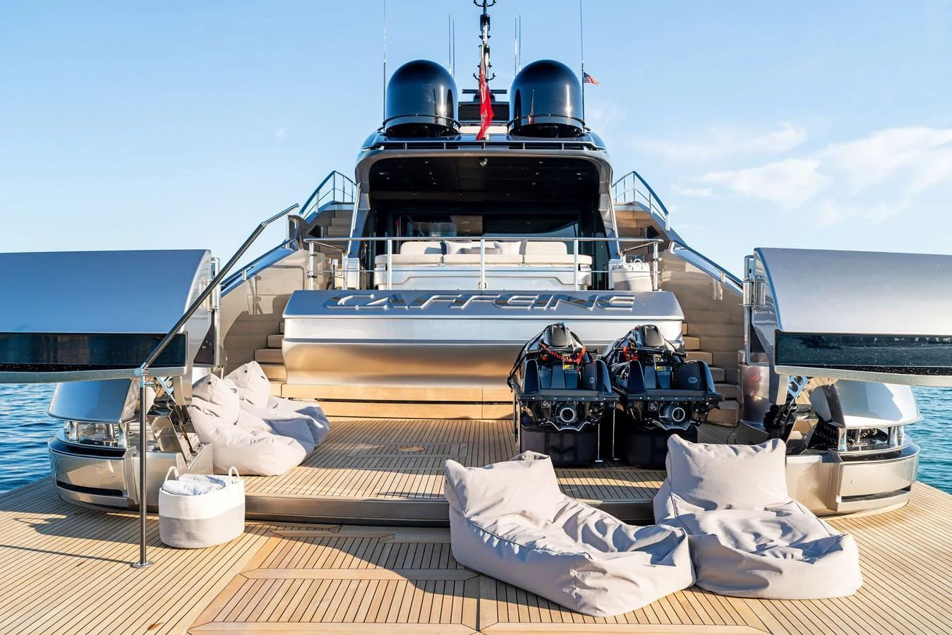 The yacht's aft deck features a spacious lounging area with plush bean bags and sleek design elements. aboard CAFFEINE Yacht for Sale