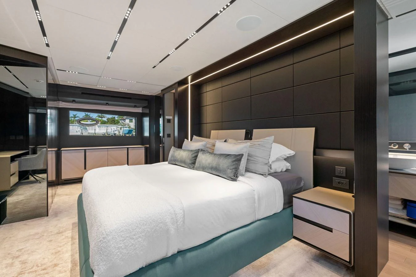 A luxurious stateroom featuring a large bed, modern decor, and ample lighting. aboard CAFFEINE Yacht for Sale