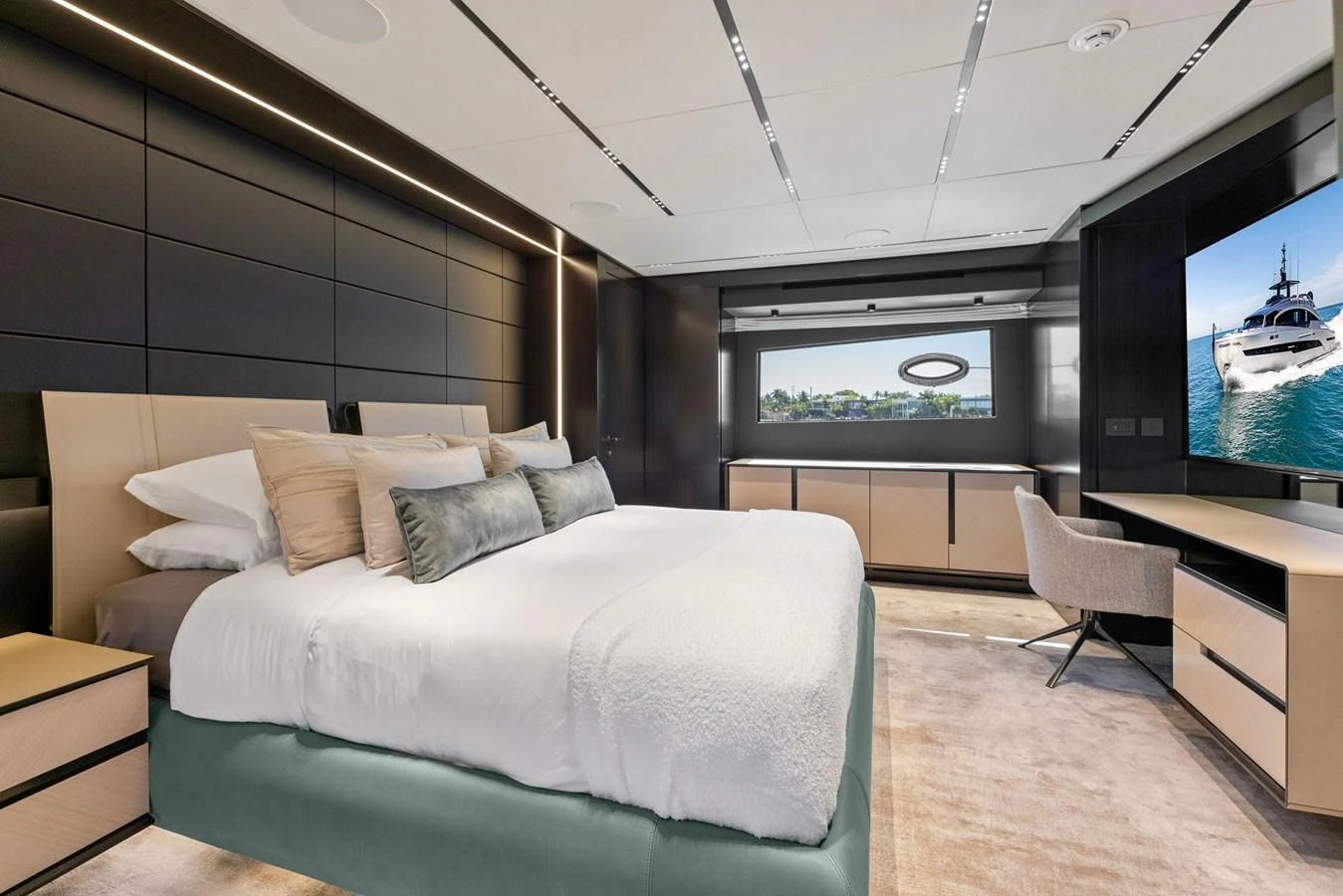 The master stateroom features a luxurious bed, modern furnishings, and a large window with a scenic view. aboard CAFFEINE Yacht for Sale