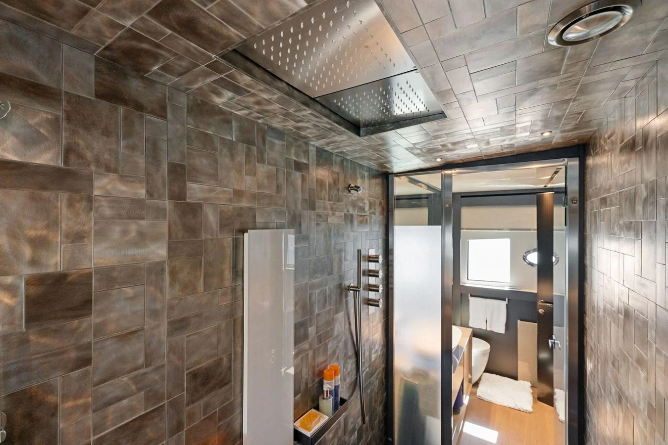 The yacht's bathroom features a modern design with sleek fixtures and a spacious shower area. aboard CAFFEINE Yacht for Sale
