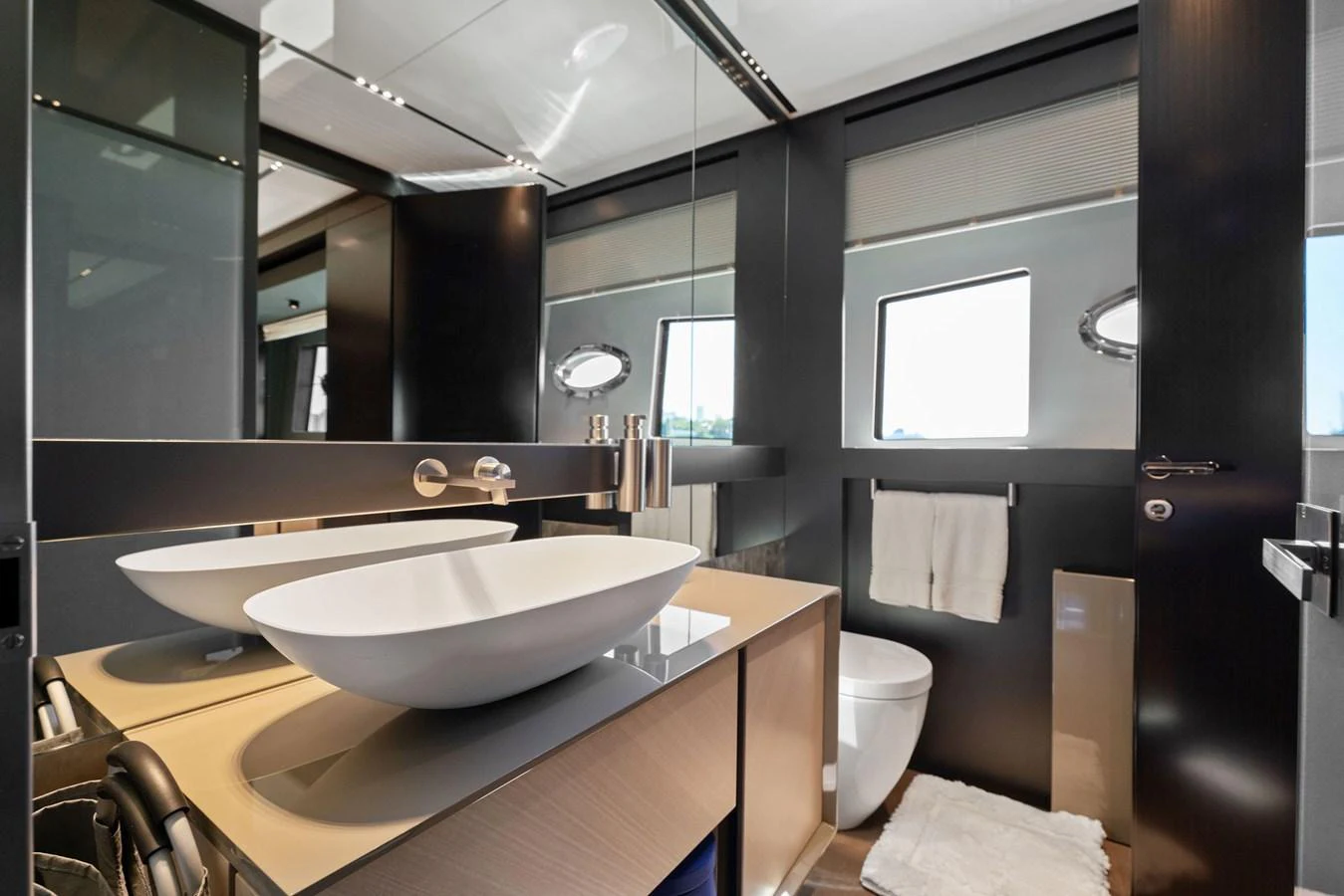 A modern yacht bathroom featuring dual vessel sinks and sleek design elements. aboard CAFFEINE Yacht for Sale