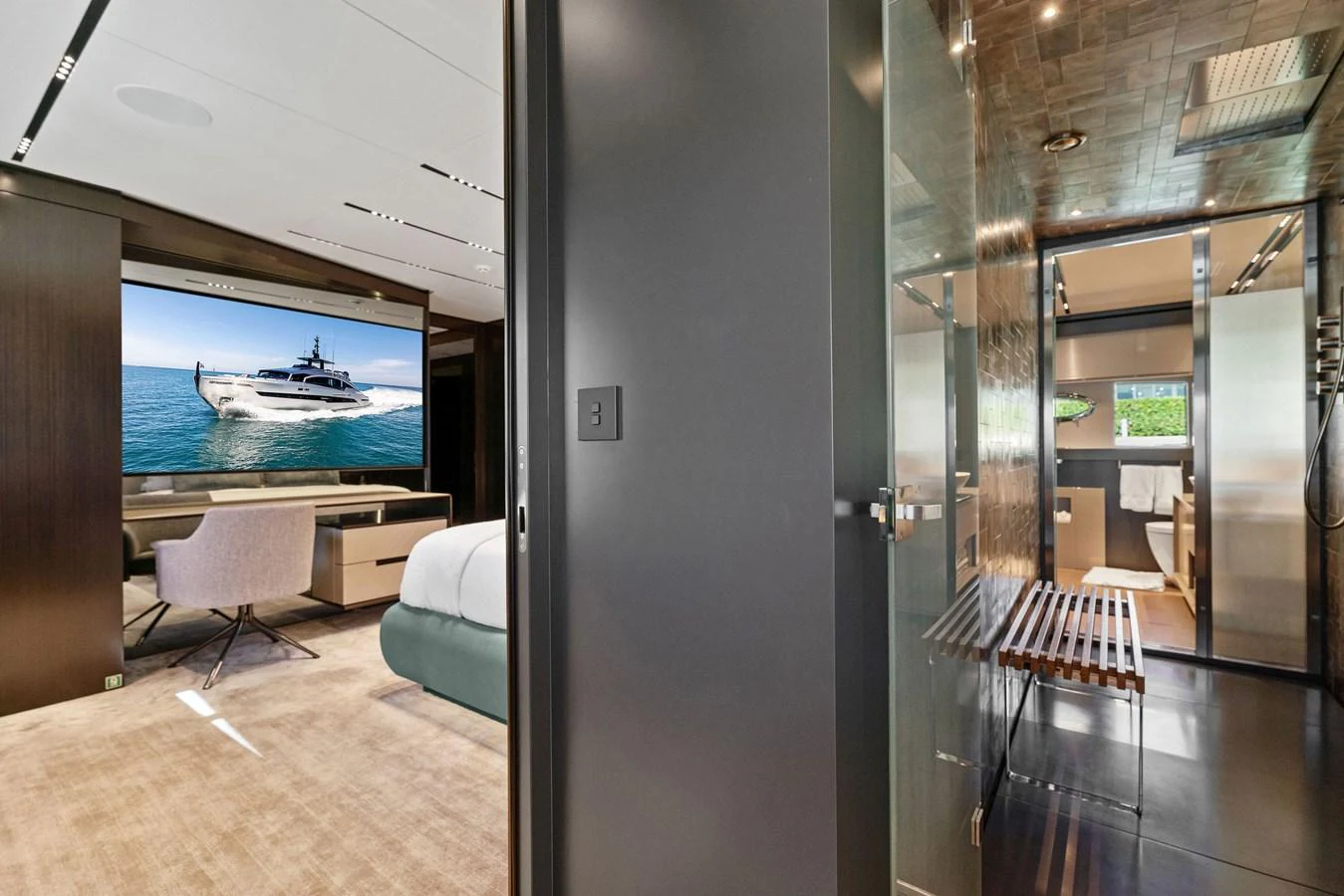 A luxurious stateroom featuring a large bed, a seating area, and an ensuite bathroom with modern amenities. aboard CAFFEINE Yacht for Sale