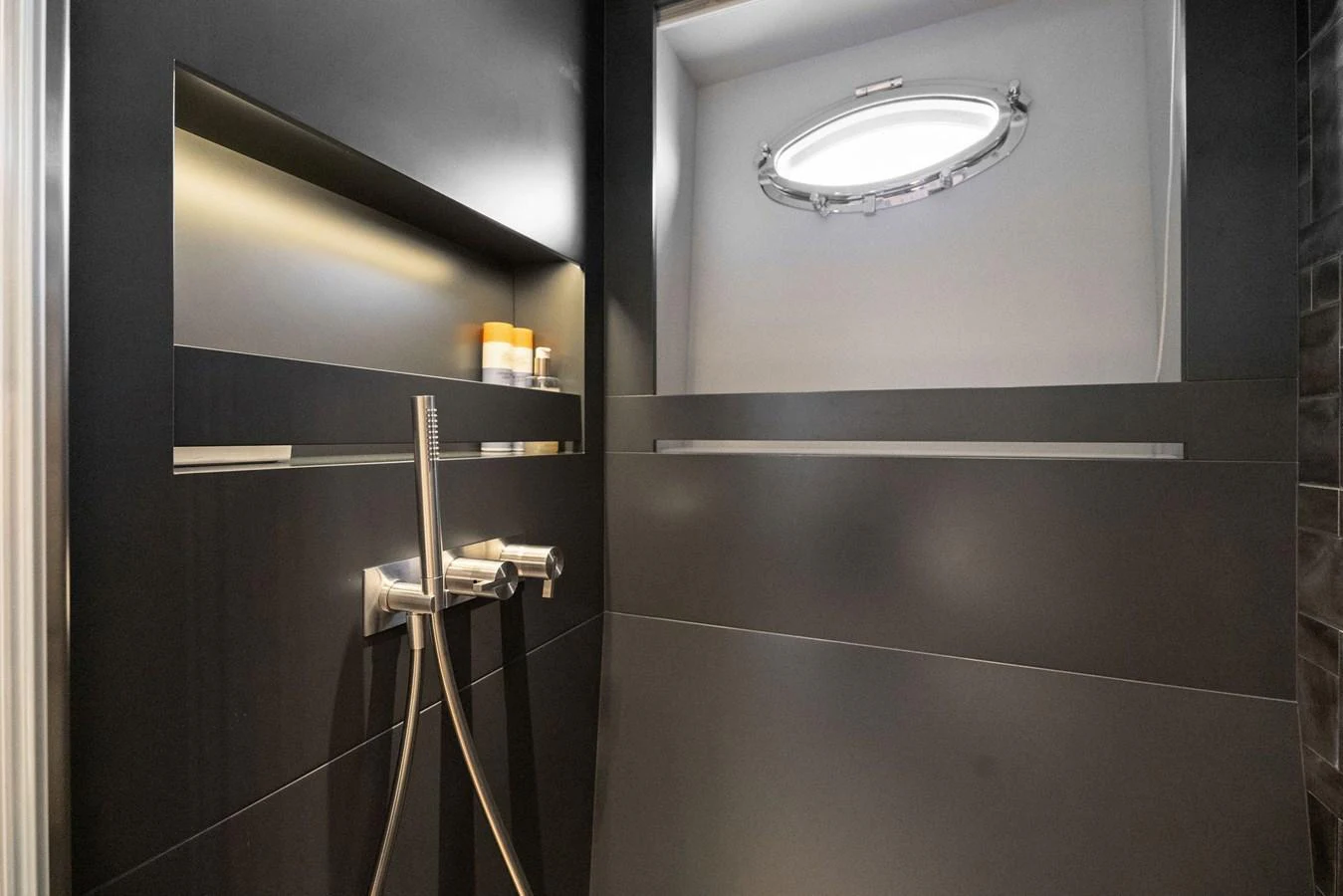 A sleek and modern yacht bathroom with a porthole window and contemporary fixtures. aboard CAFFEINE Yacht for Sale