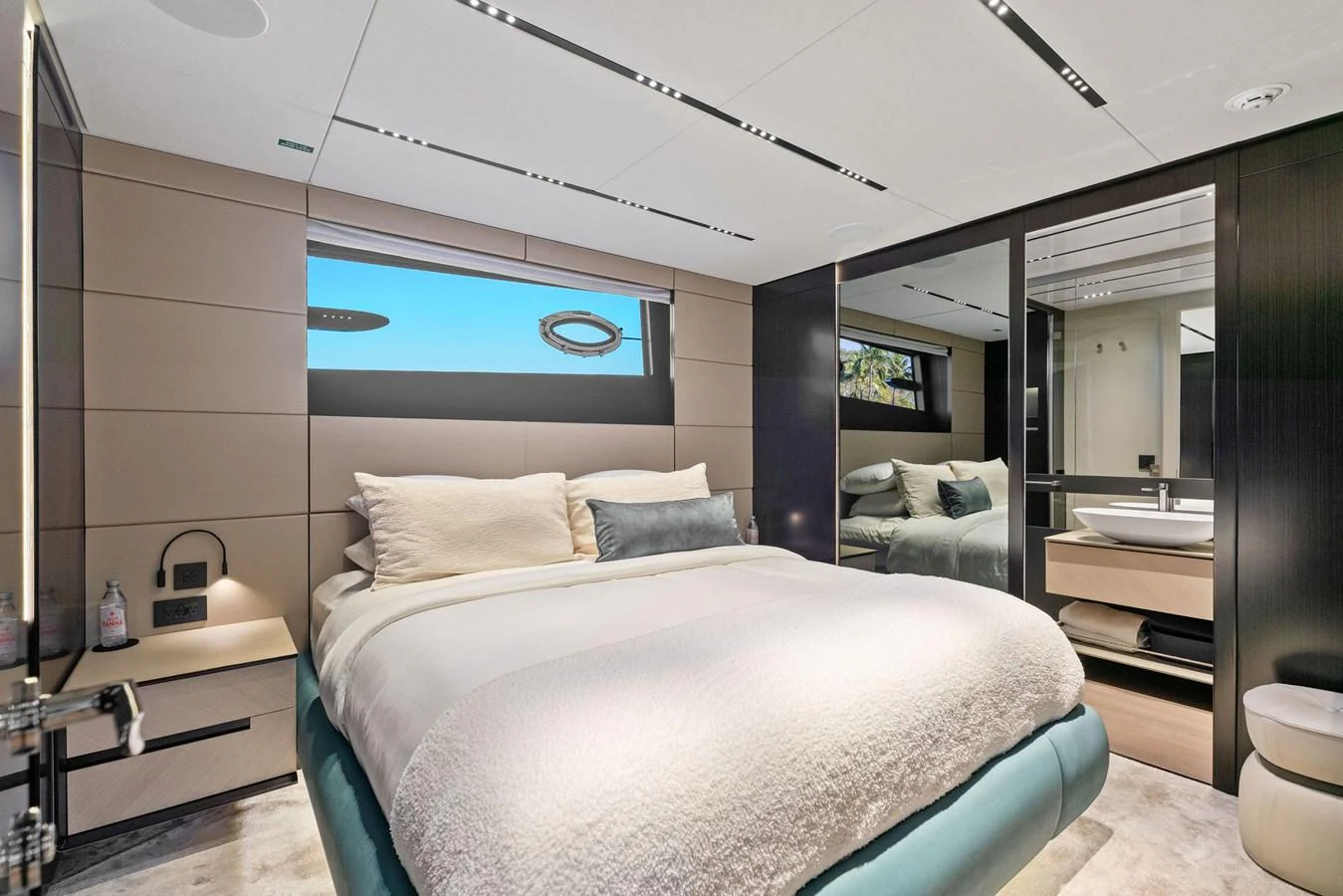 The stateroom features a luxurious bed with modern decor and ample natural light. aboard CAFFEINE Yacht for Sale