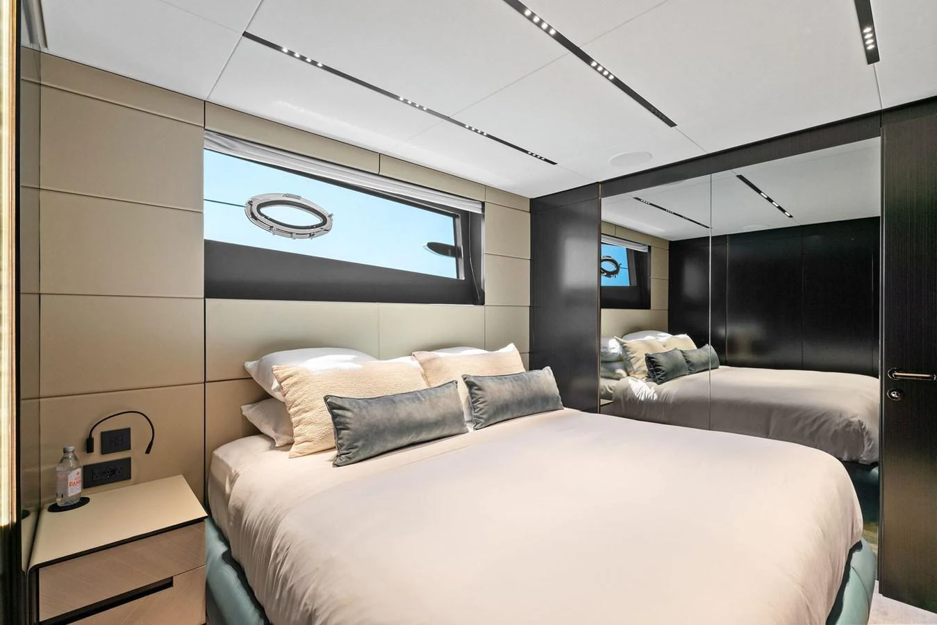 A luxurious stateroom featuring a large bed, modern decor, and ample natural light. aboard CAFFEINE Yacht for Sale