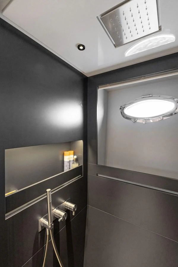 A sleek and modern yacht bathroom with a porthole window and contemporary fixtures. aboard CAFFEINE Yacht for Sale