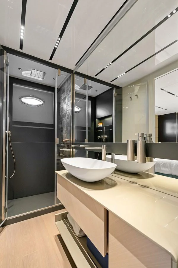 A sleek and modern bathroom with a glass-enclosed shower and stylish fixtures. aboard CAFFEINE Yacht for Sale