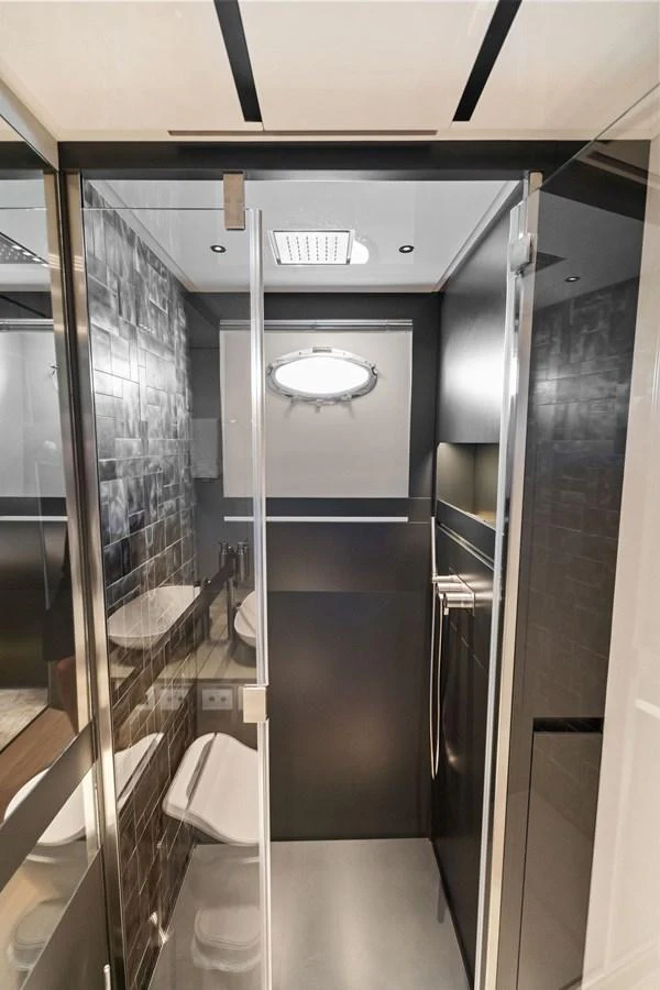 A sleek and modern yacht bathroom featuring a glass shower enclosure and contemporary fixtures. aboard CAFFEINE Yacht for Sale