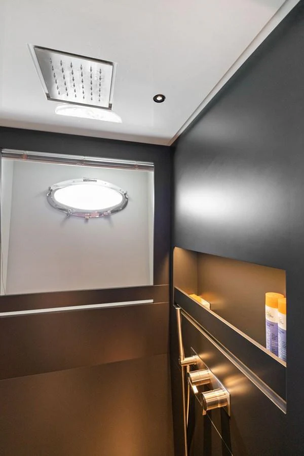 A sleek and modern yacht bathroom with a porthole and contemporary fixtures. aboard CAFFEINE Yacht for Sale
