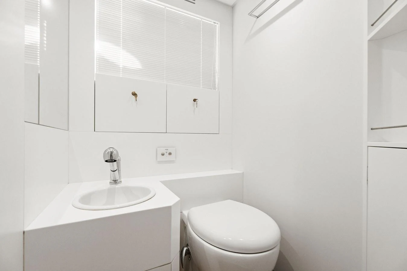A pristine and modern yacht bathroom with sleek white fixtures. aboard CAFFEINE Yacht for Sale