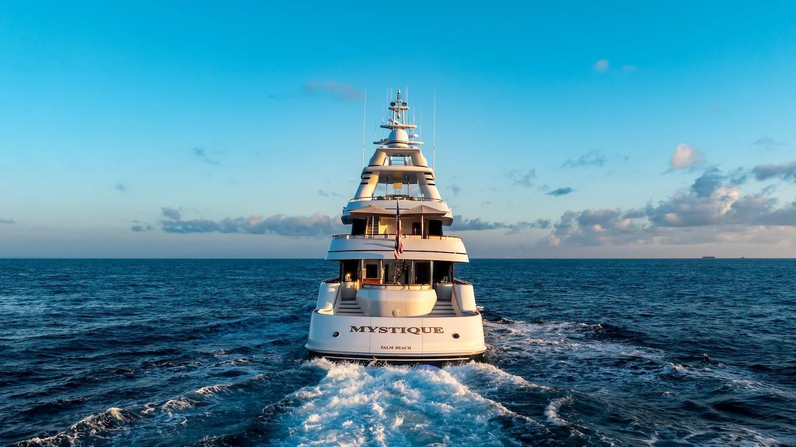 The yacht sails gracefully on the open sea, showcasing its elegant design against a backdrop of blue waters and sky. aboard MYSTIQUE Yacht for Sale