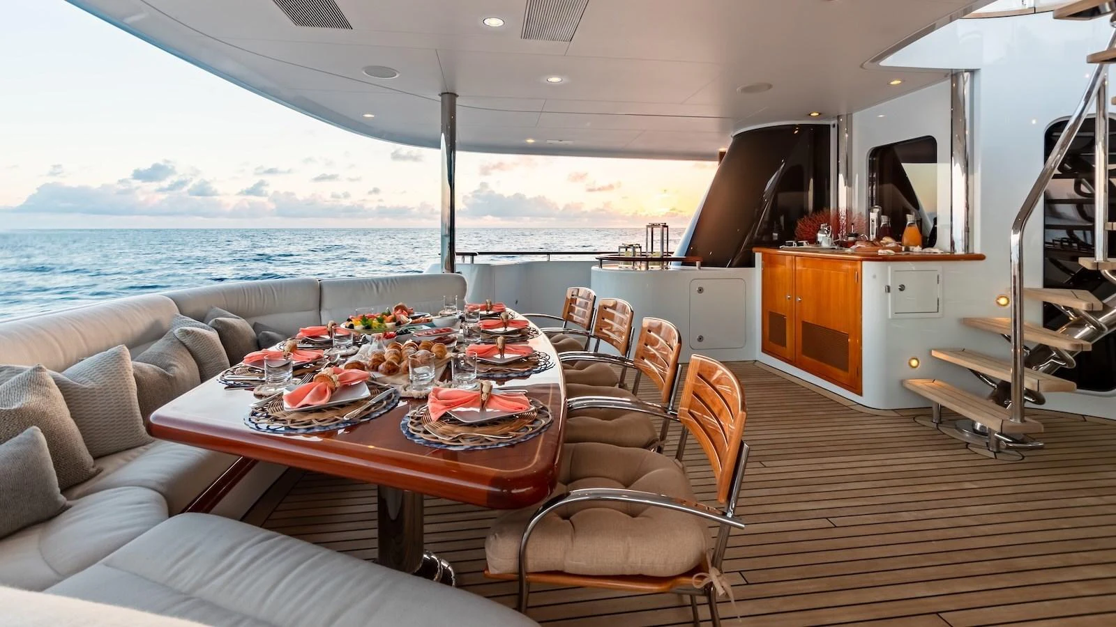 The aft deck features an elegant dining area with a stunning ocean view. aboard MYSTIQUE Yacht for Sale