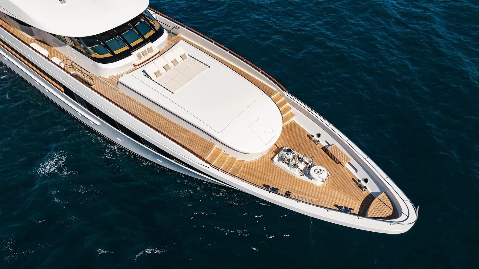 A sleek and modern yacht glides through the deep blue sea, showcasing its expansive deck and luxurious design. aboard MYSTIQUE Yacht for Sale