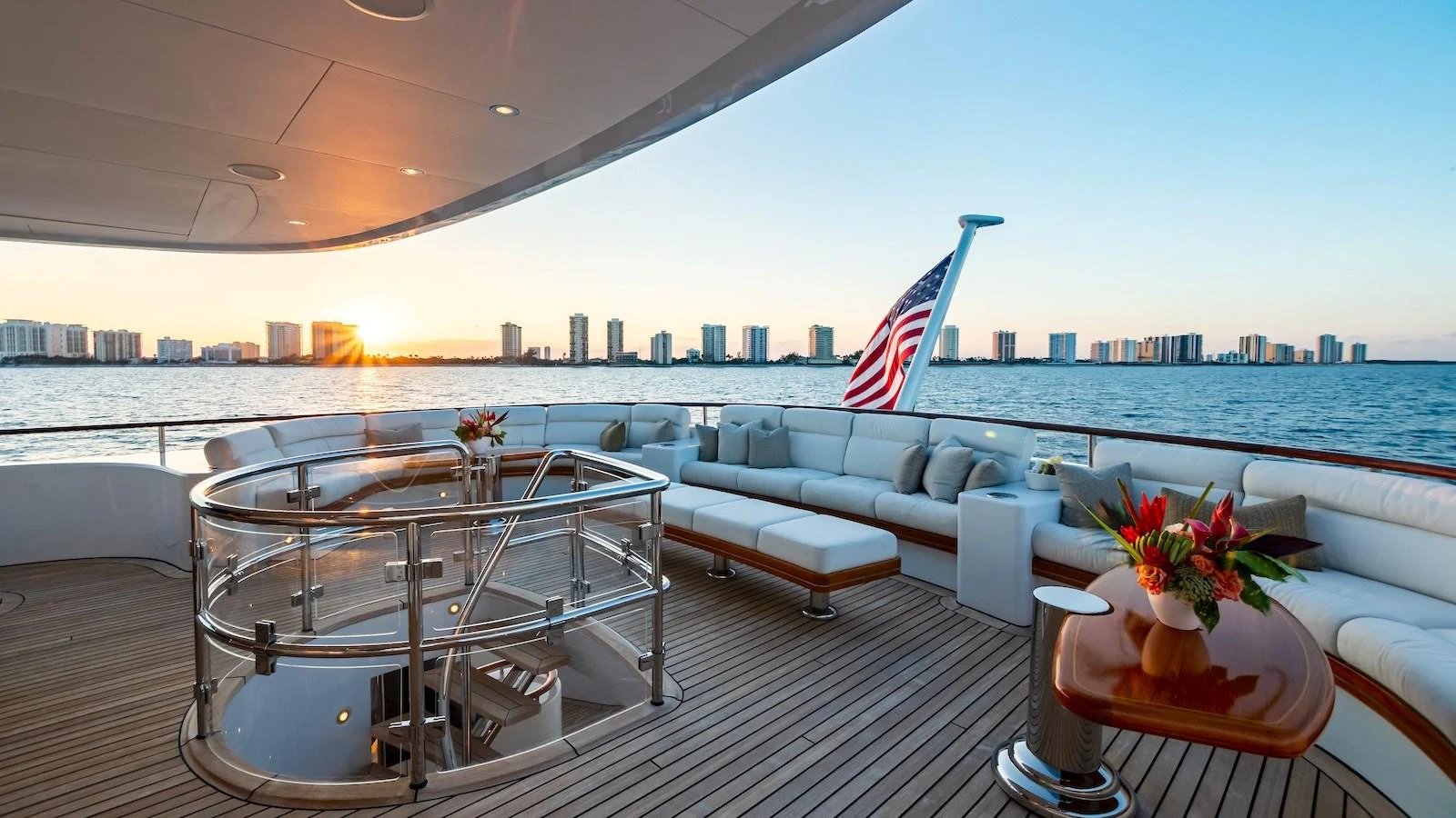 The aft deck offers a luxurious seating area with a stunning view of the sunset over the water. aboard MYSTIQUE Yacht for Sale