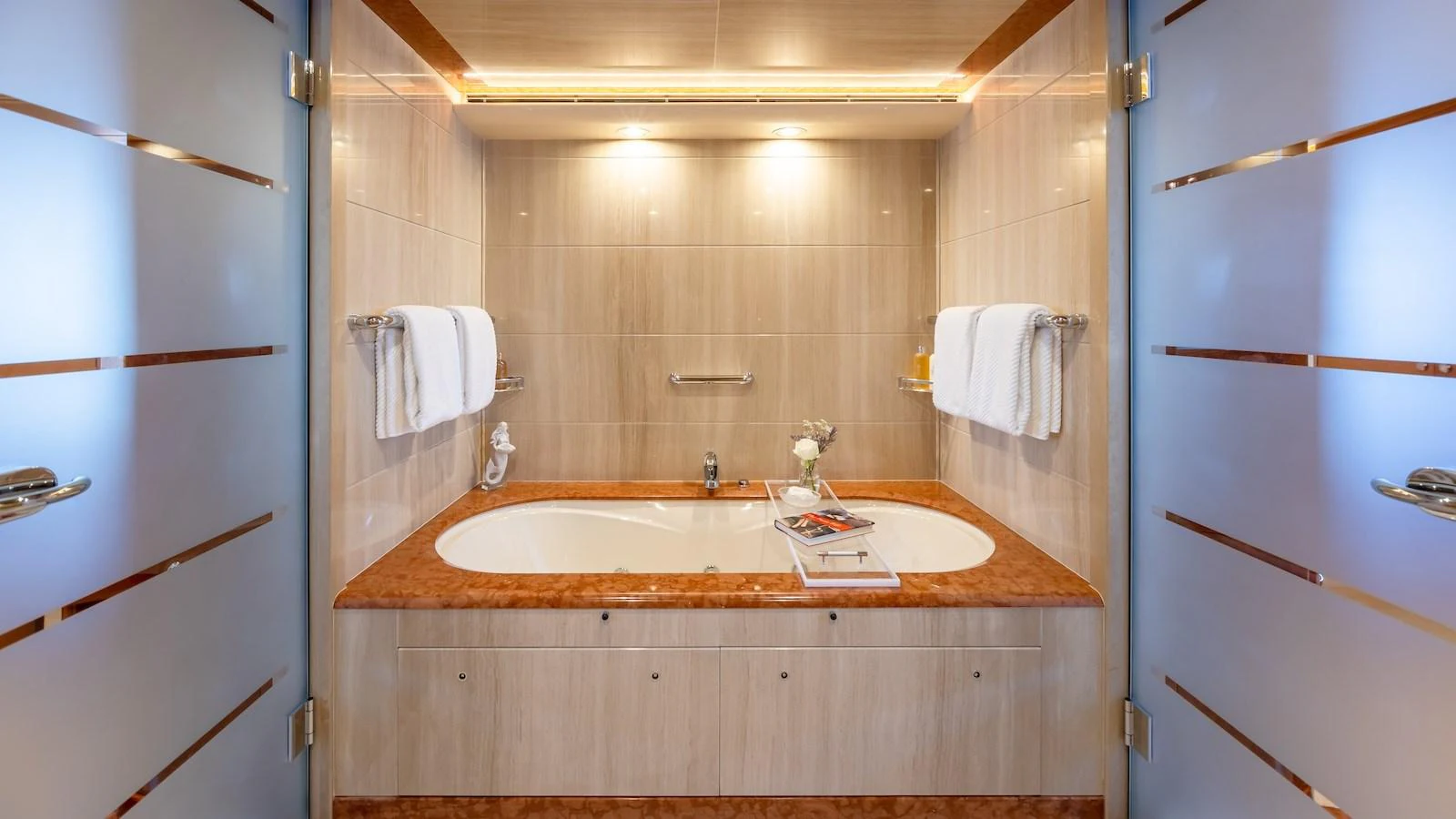 The yacht's bathroom features a luxurious bathtub with elegant fixtures and ample lighting. aboard MYSTIQUE Yacht for Sale