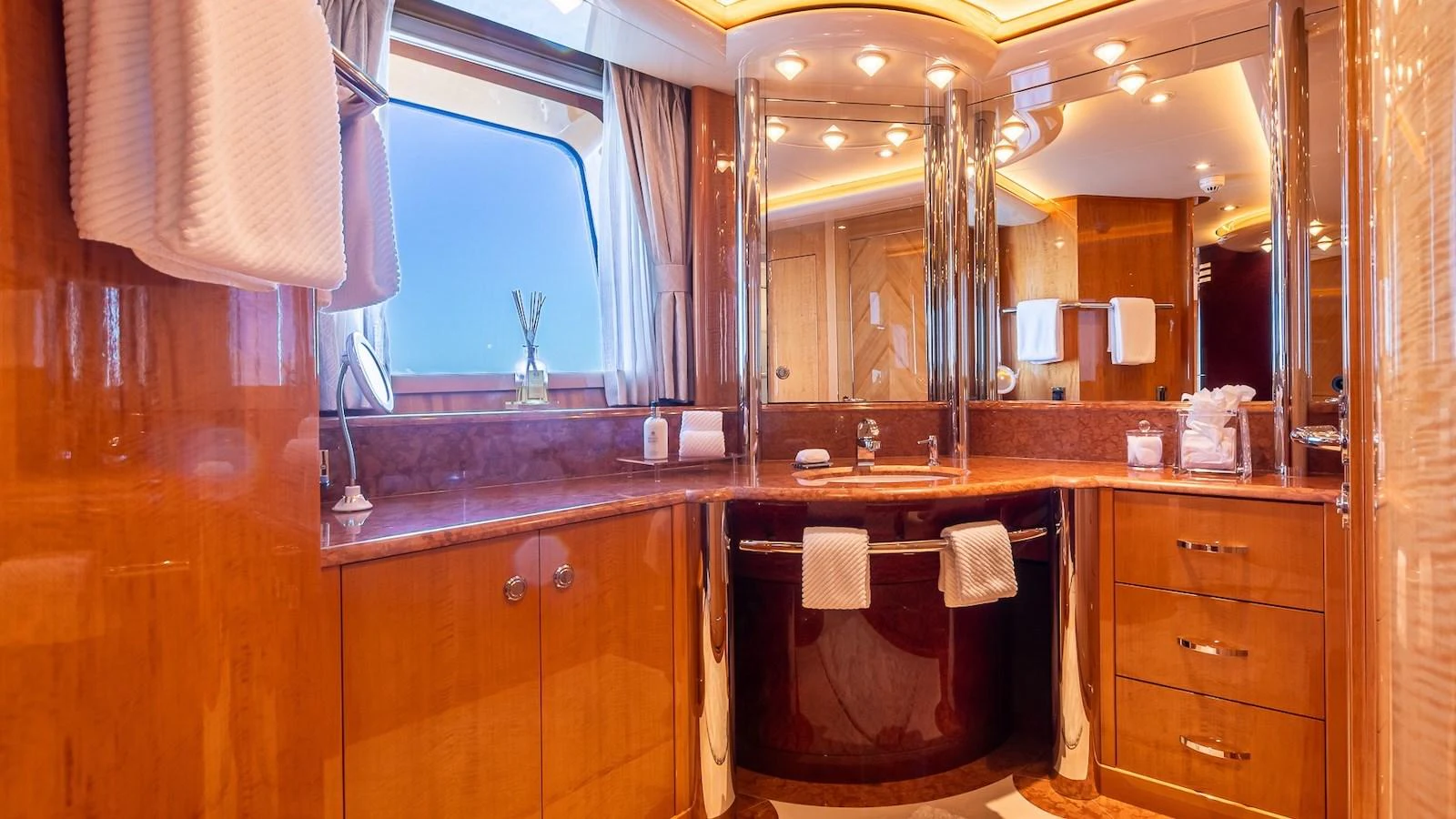 The yacht's bathroom features luxurious wood finishes and ample lighting. aboard MYSTIQUE Yacht for Sale