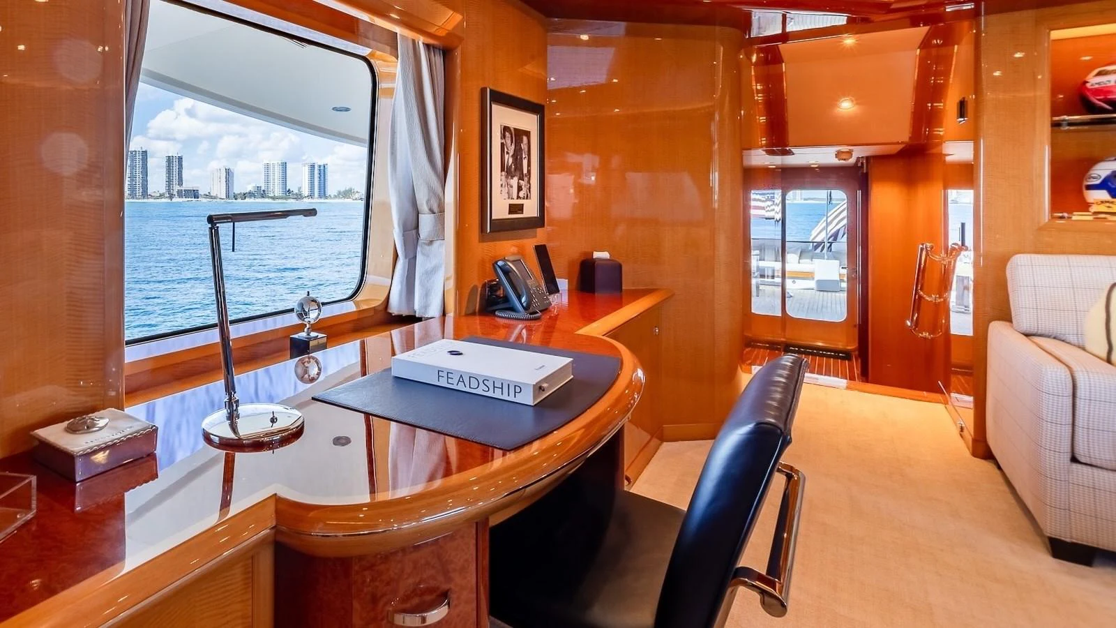 The yacht's office features a sleek desk with a view of the water and city skyline. aboard MYSTIQUE Yacht for Sale