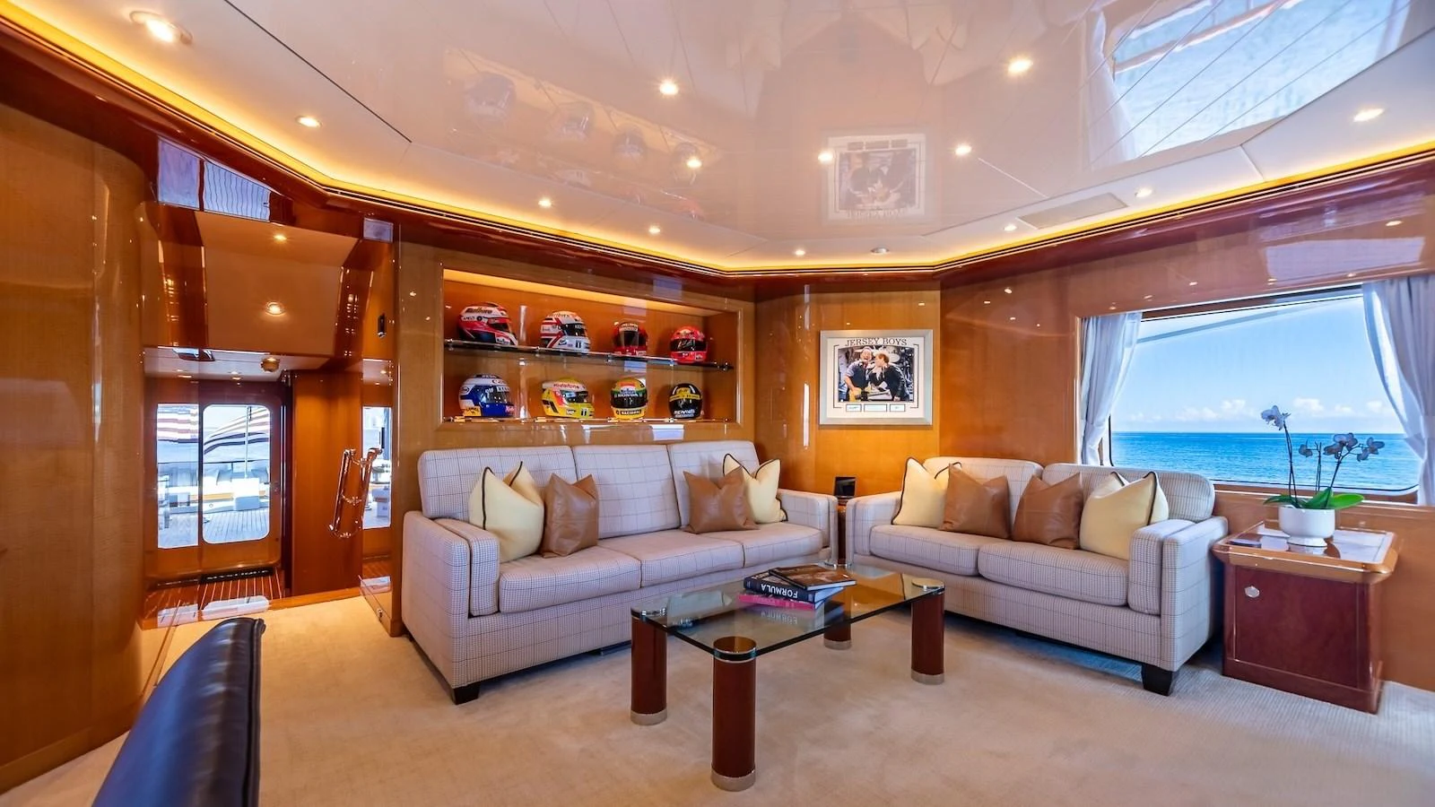 The salon features plush seating, elegant decor, and large windows offering stunning ocean views. aboard MYSTIQUE Yacht for Sale