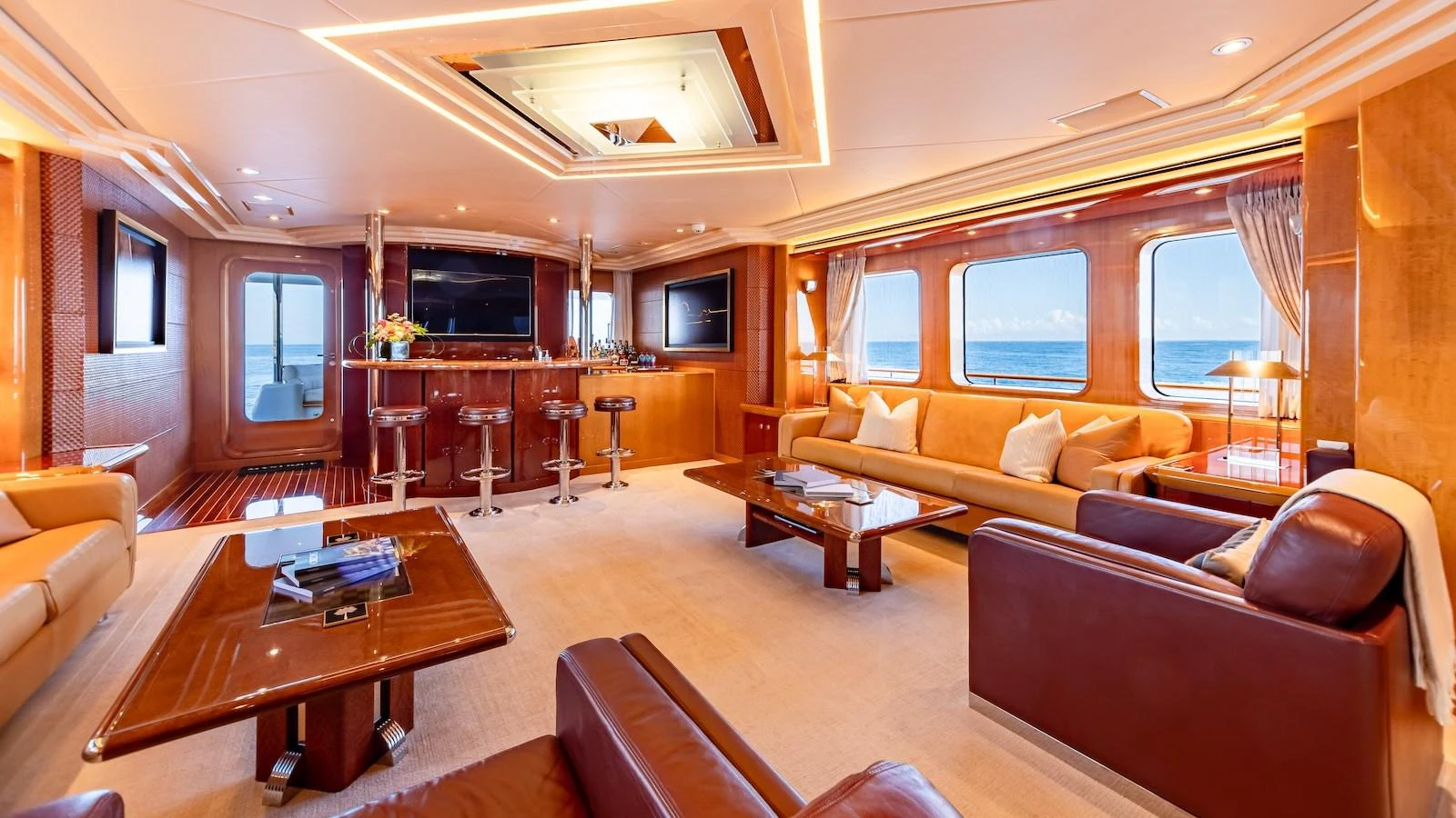 The salon features luxurious seating, a bar area, and large windows offering stunning ocean views. aboard MYSTIQUE Yacht for Sale