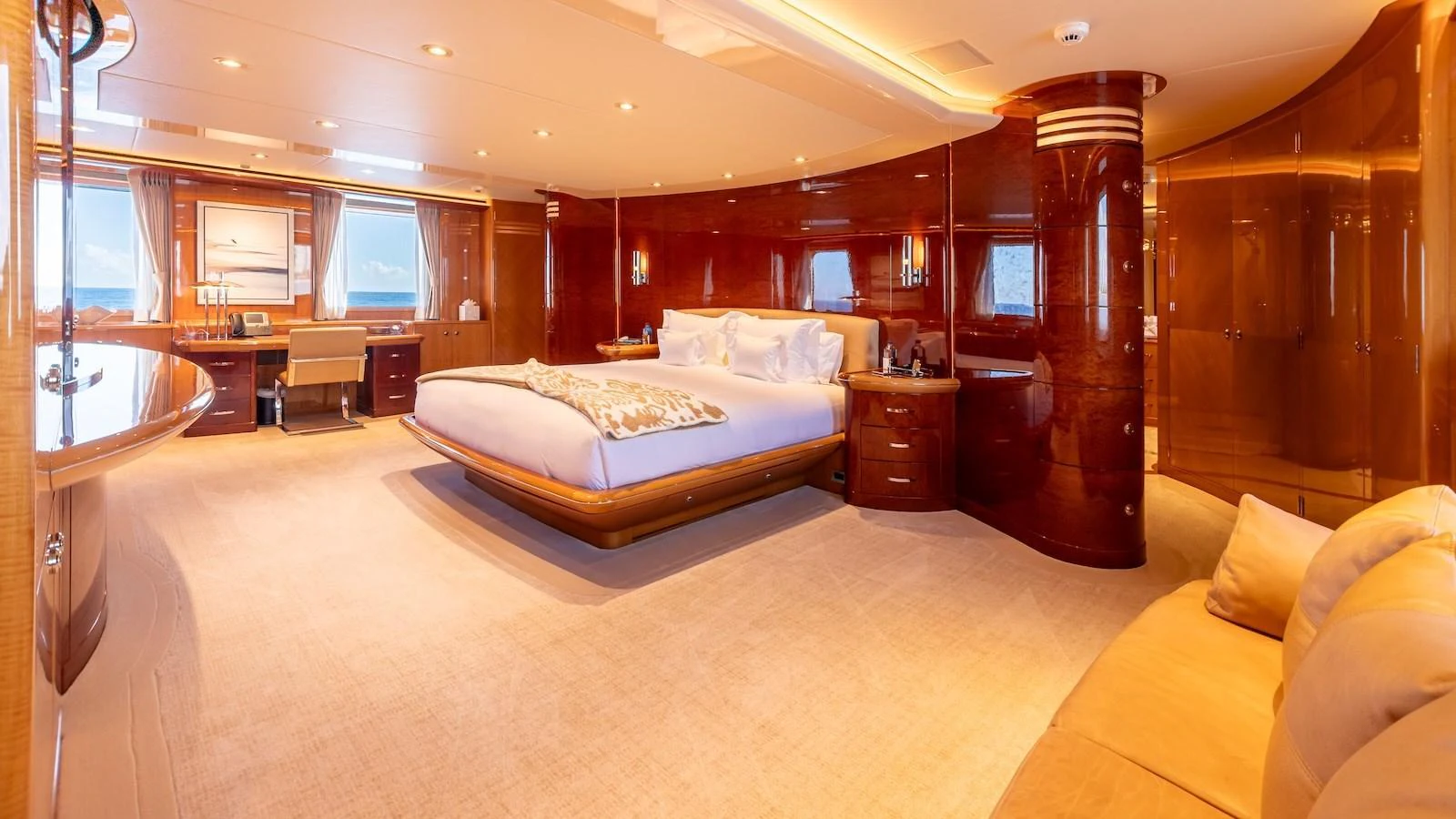 The master stateroom features luxurious wood finishes, a large bed, and ample natural light. aboard MYSTIQUE Yacht for Sale
