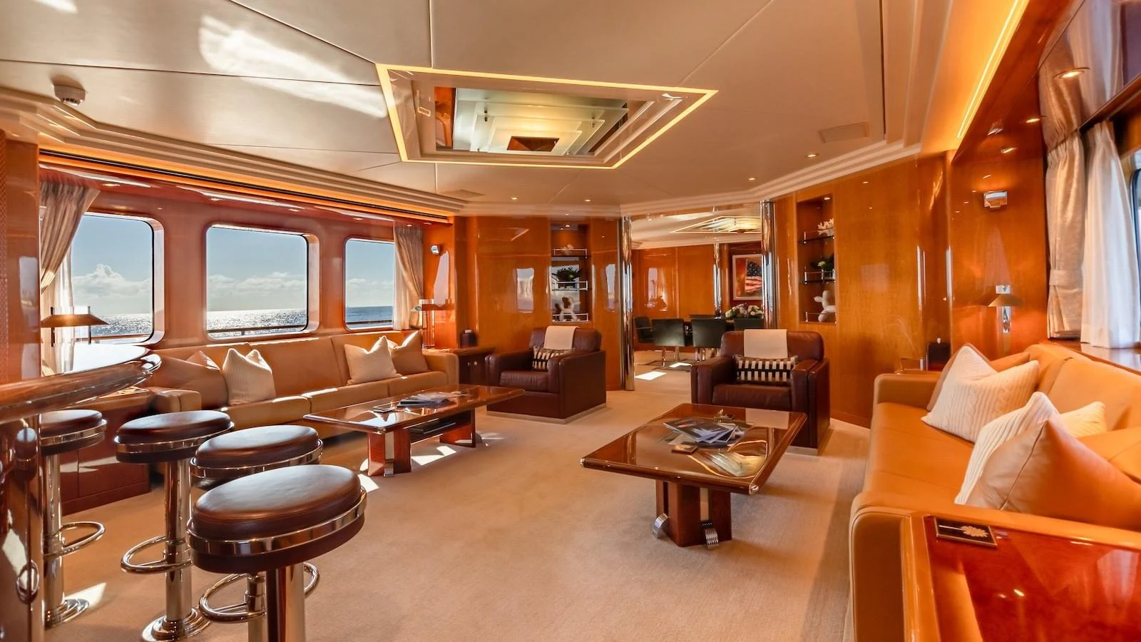 The salon features luxurious seating with panoramic windows offering stunning sea views. aboard MYSTIQUE Yacht for Sale