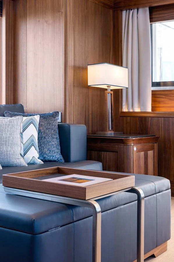 The yacht's interior features a cozy seating area with elegant wooden paneling and modern decor. aboard EMPIRE Yacht for Sale