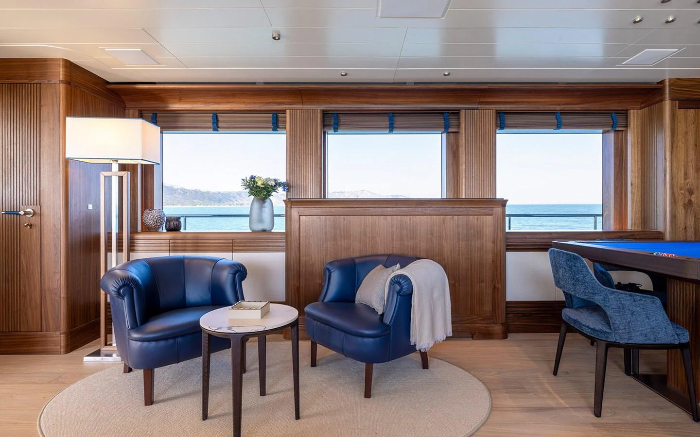 The salon features elegant seating with a view of the ocean through large windows. aboard EMPIRE Yacht for Sale