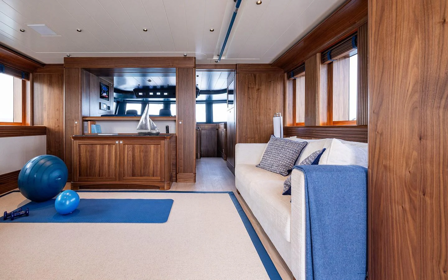 The yacht's interior gym features a comfortable seating area and exercise equipment, creating a perfect space for onboard fitness. aboard EMPIRE Yacht for Sale