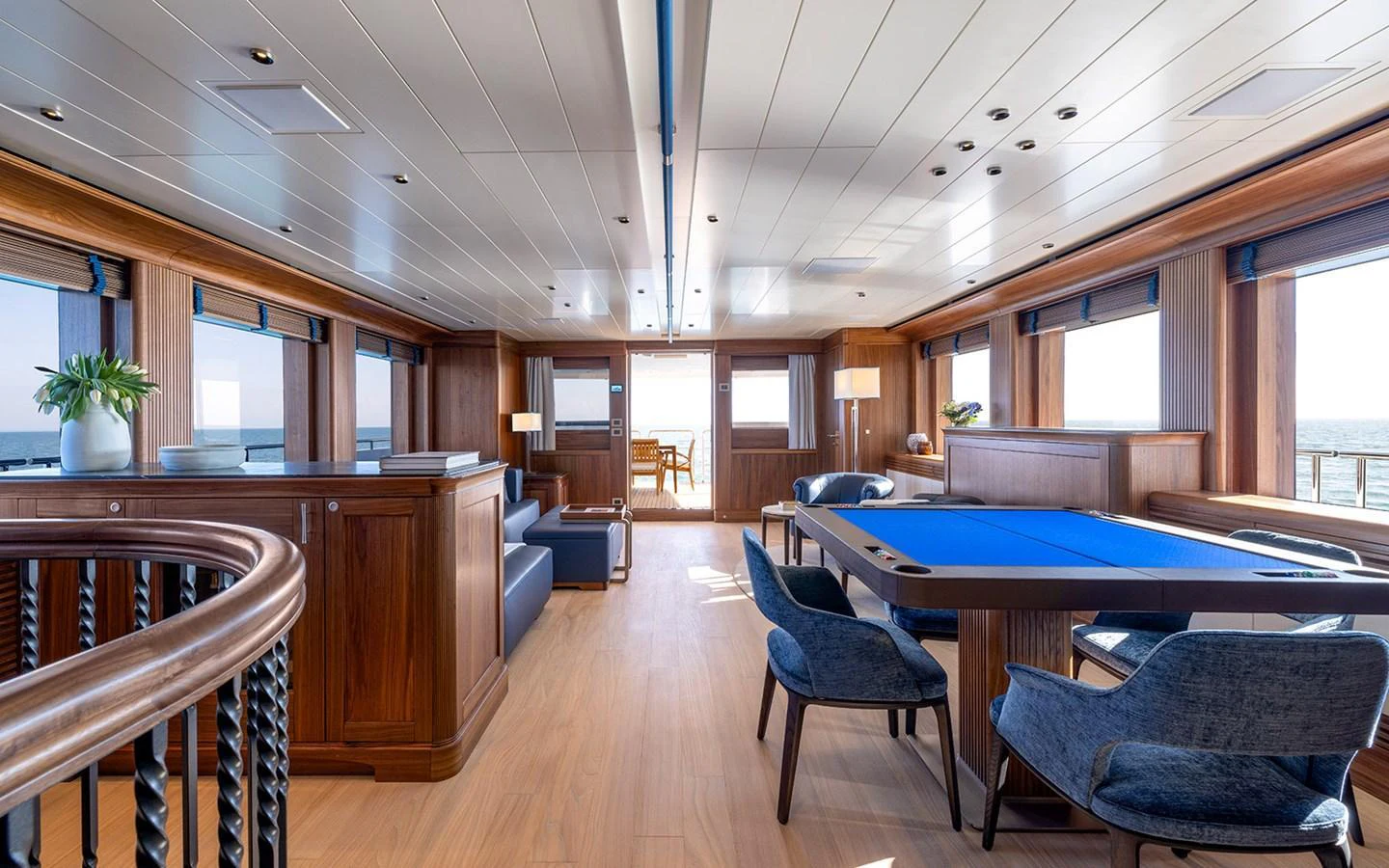 The spacious salon features elegant wood paneling, comfortable seating, and a pool table, offering a luxurious and inviting atmosphere. aboard EMPIRE Yacht for Sale
