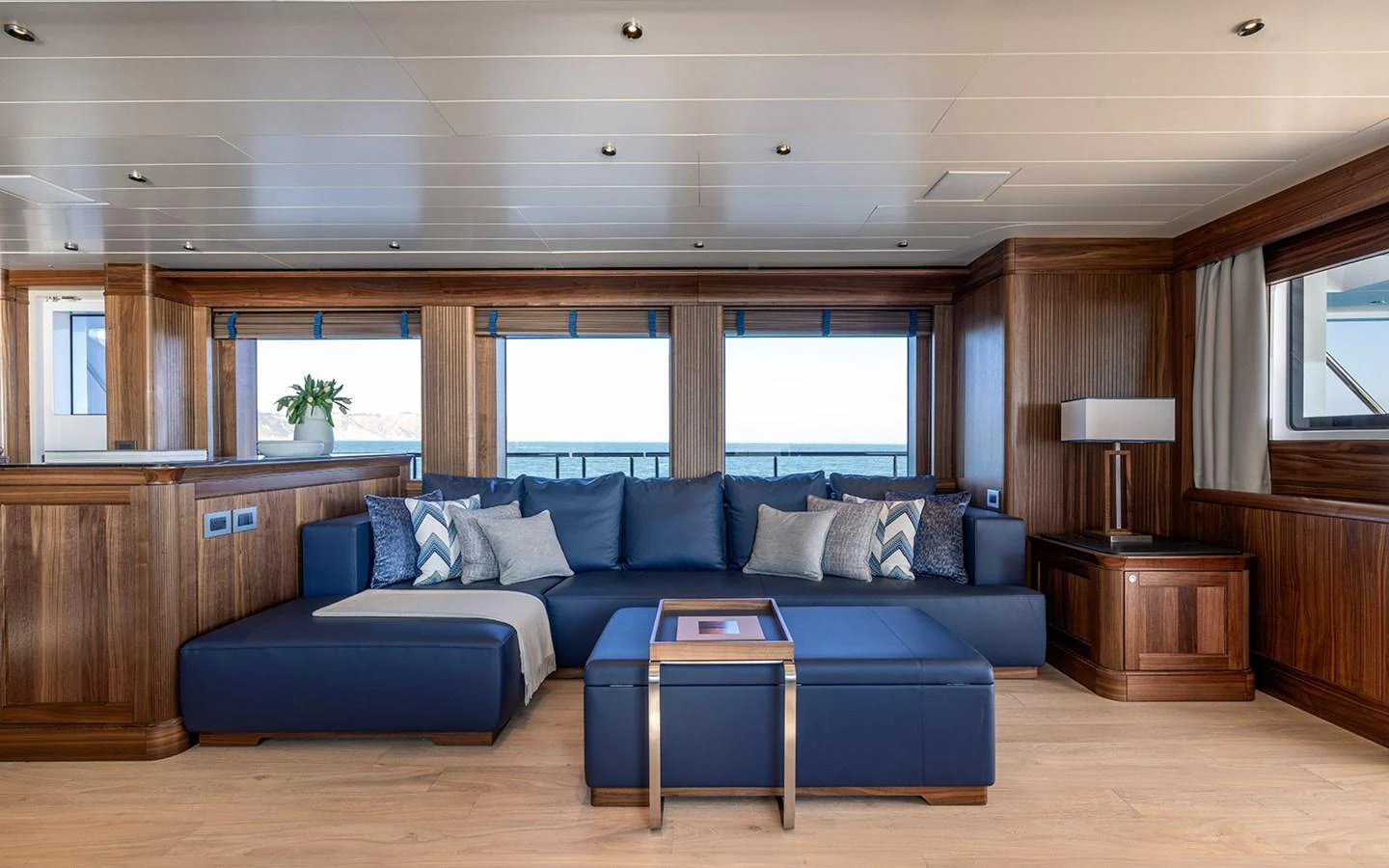 The salon features a spacious seating area with elegant wood paneling and large windows offering stunning sea views. aboard EMPIRE Yacht for Sale