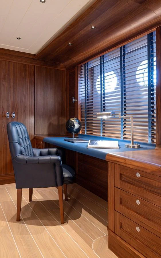 A sophisticated yacht office with rich wood paneling and a sleek desk setup. aboard EMPIRE Yacht for Sale